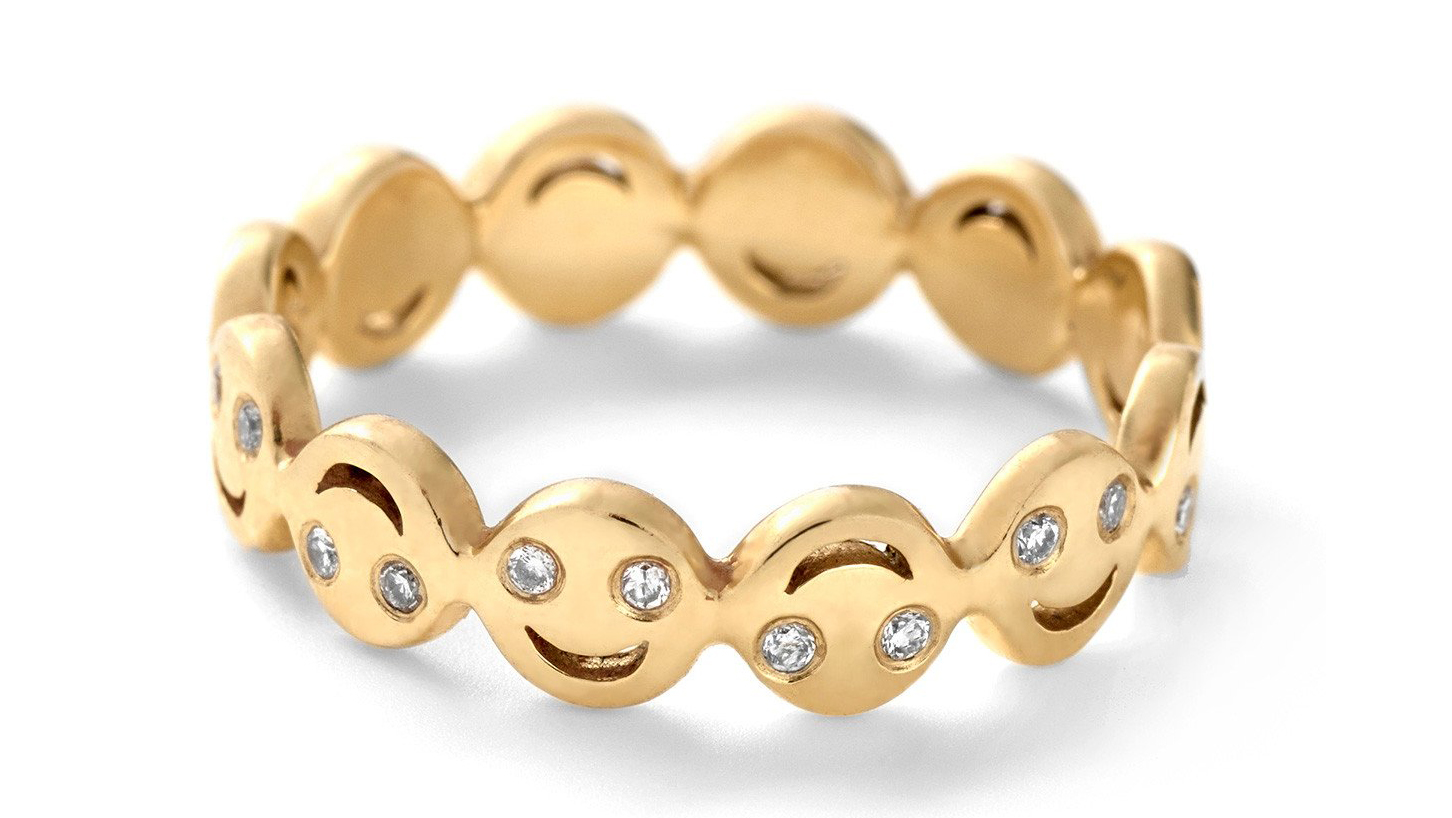 Round cut diamonds set within a gold happy face diamond emoji ring from Alison Lou