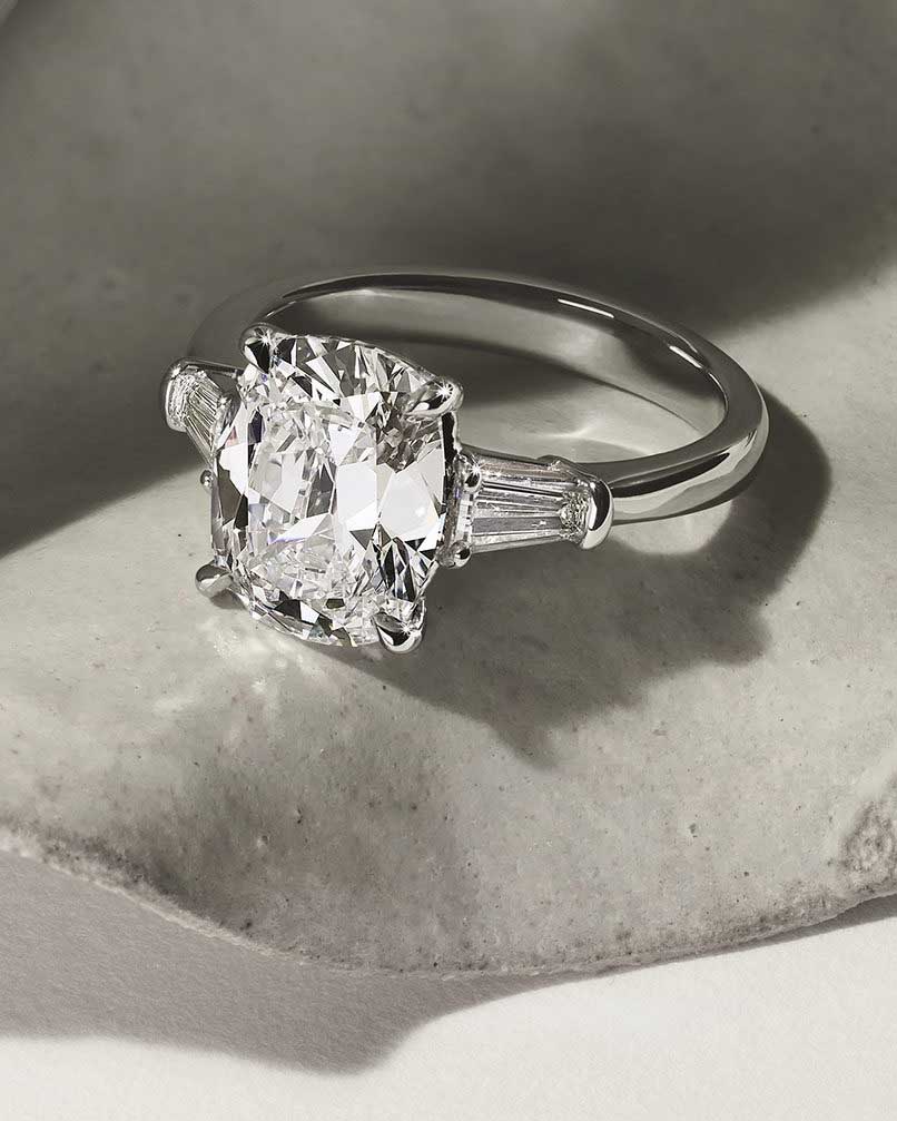 Princess cut diamond engagement ring with two baguette side stones on a platinum band