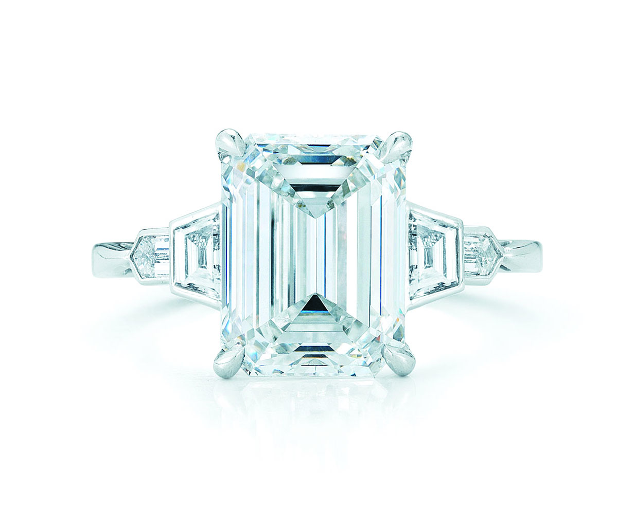 Emerald cut diamond ring with trapezoid side stones in art deco style with a white gold band