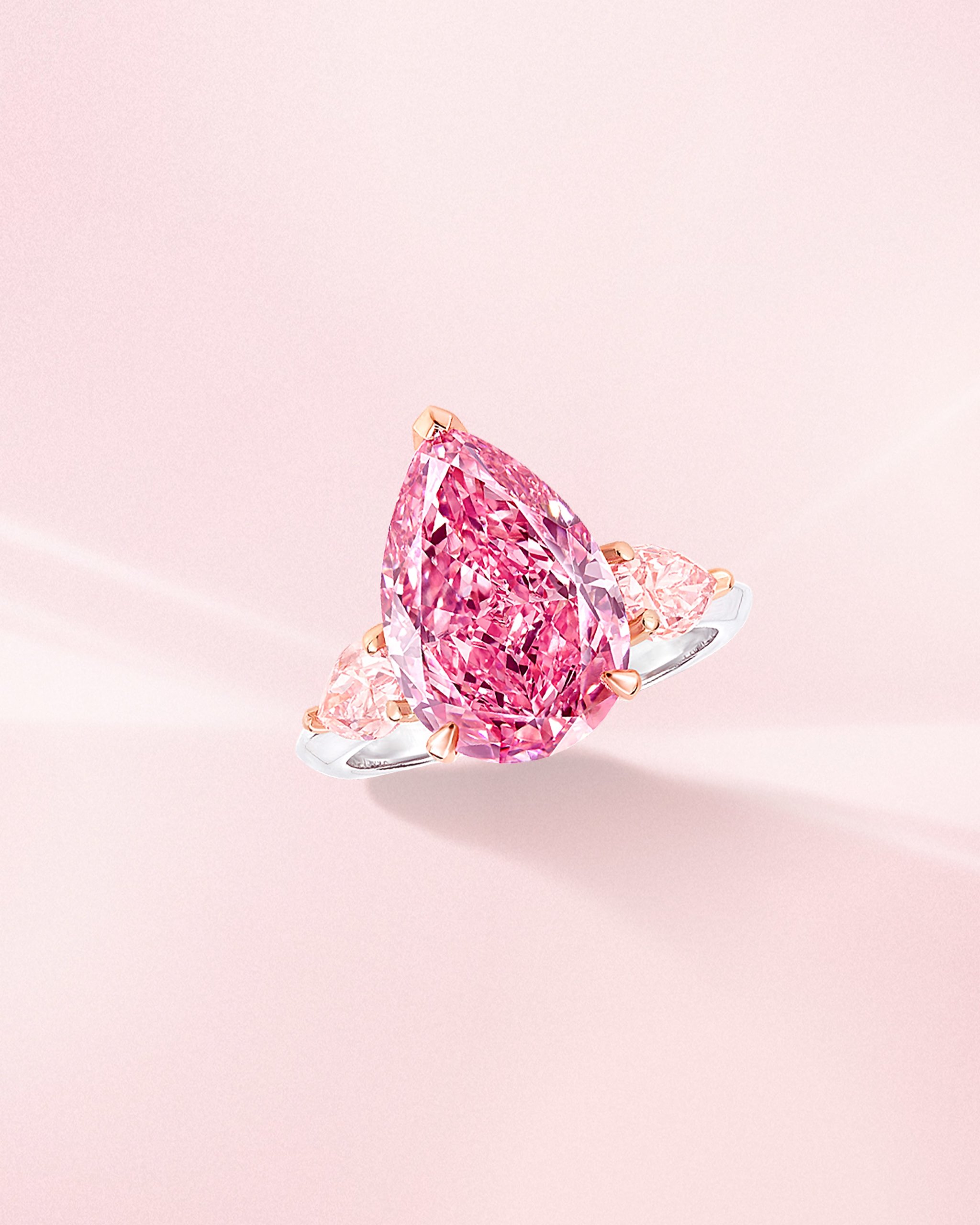 Fancy vivid pink pear shaped diamond ring with side light pink diamonds on a platinum band from Graff