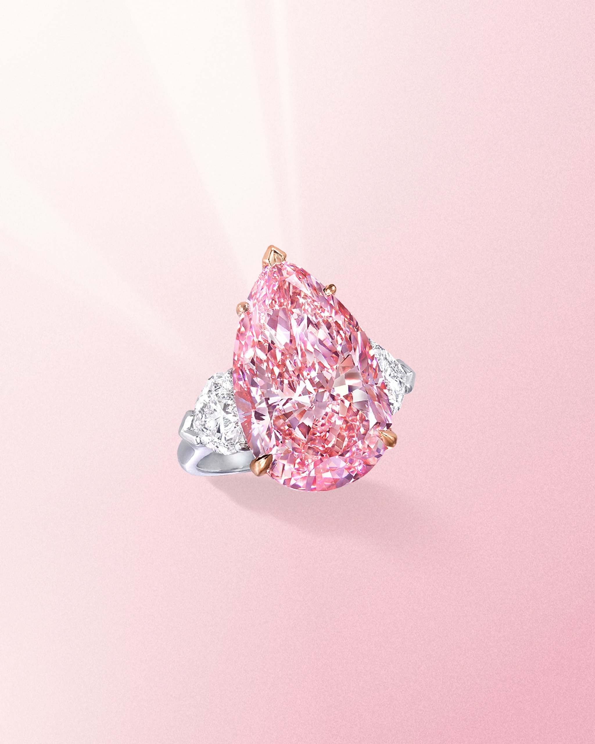 Fancy vivid pear shaped pink diamond ring with side white diamonds on a platinum band from Graff