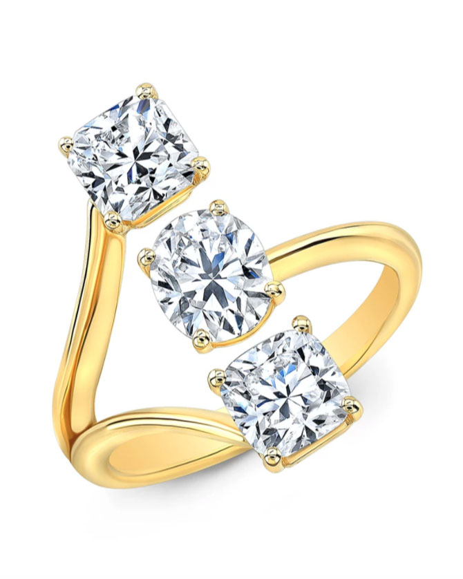 Three stone oval, square, and cushion cut diamond ring set within 18k gold