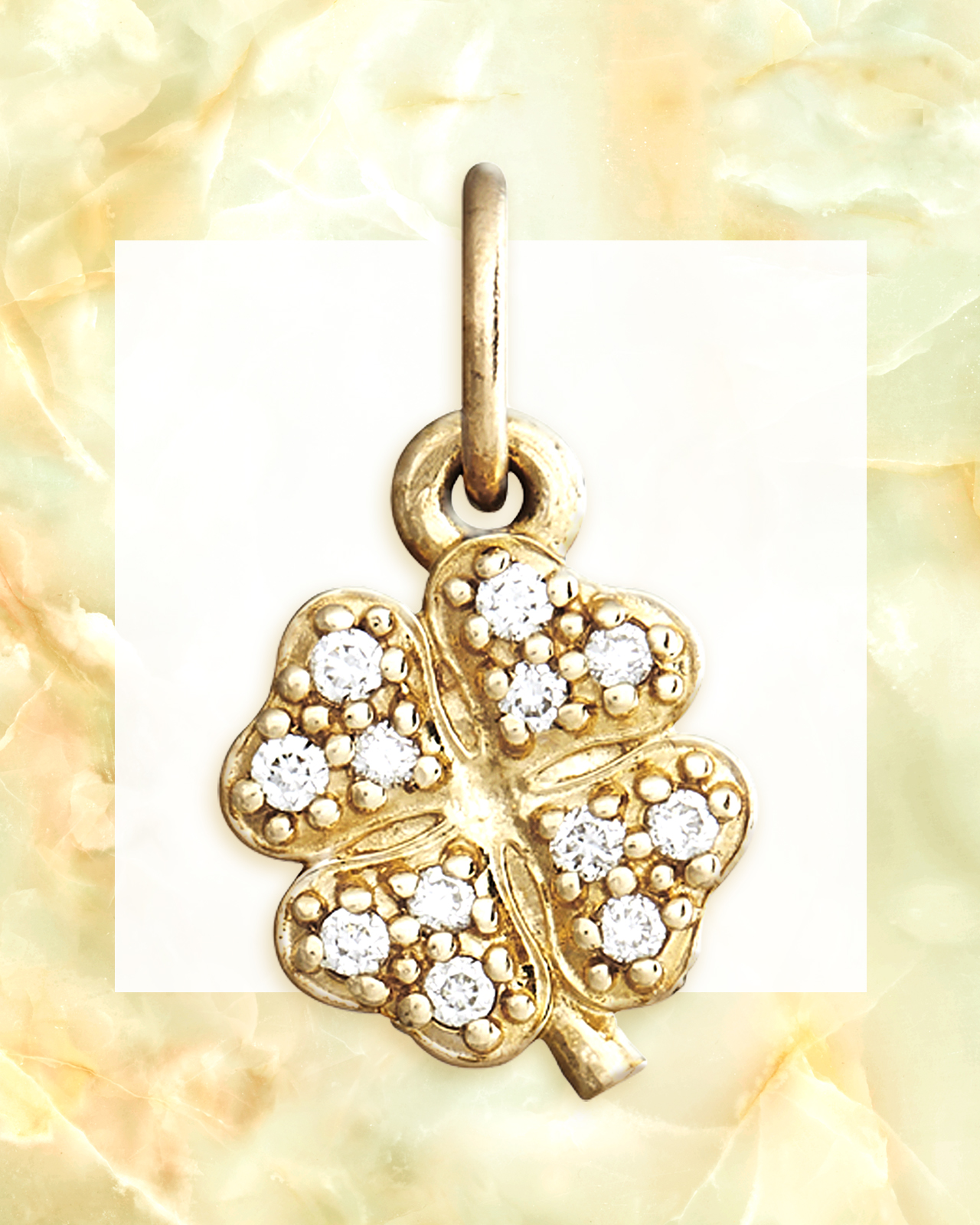Round cut diamonds set within a yellow gold four leaf clover charm pendant from Helen Ficalora