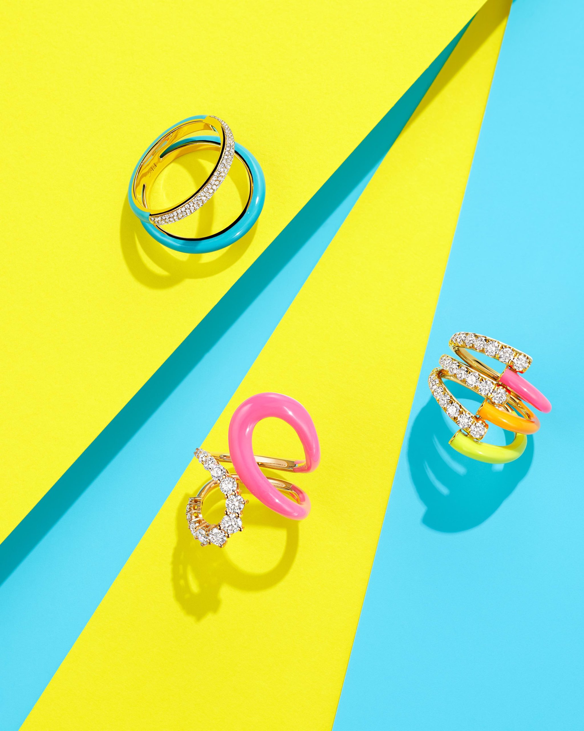 Diamonds Get Playful with Blasts of High-Octane Color 3 Bright blue enamel and diamond two band ring by EF Collection, pink, orange & yellow enamel and diamond vine ring by Melissa Kaye, and abstract bright pink enamel & diamond band ring by Melissa Kaye