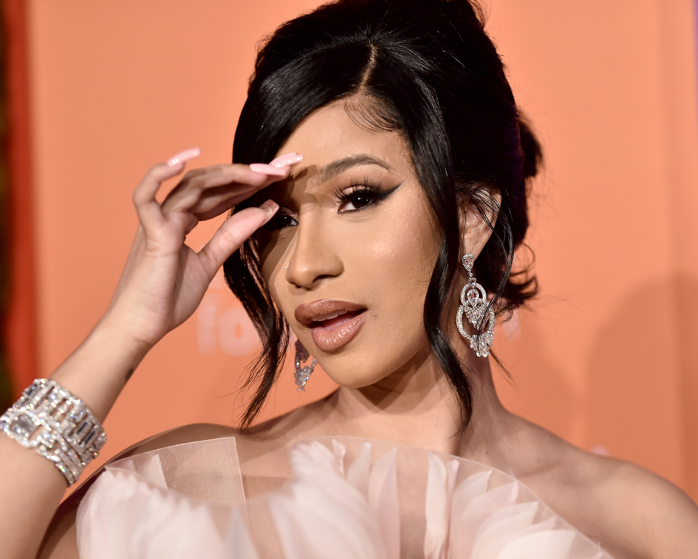 Cardi B red carpet look at Rihanna's 2019 Diamond Ball featuring a stack of diamond bracelets, diamond nose stud, and diamond chandelier earrings with diamond briolettes from Lorraine Schwartz