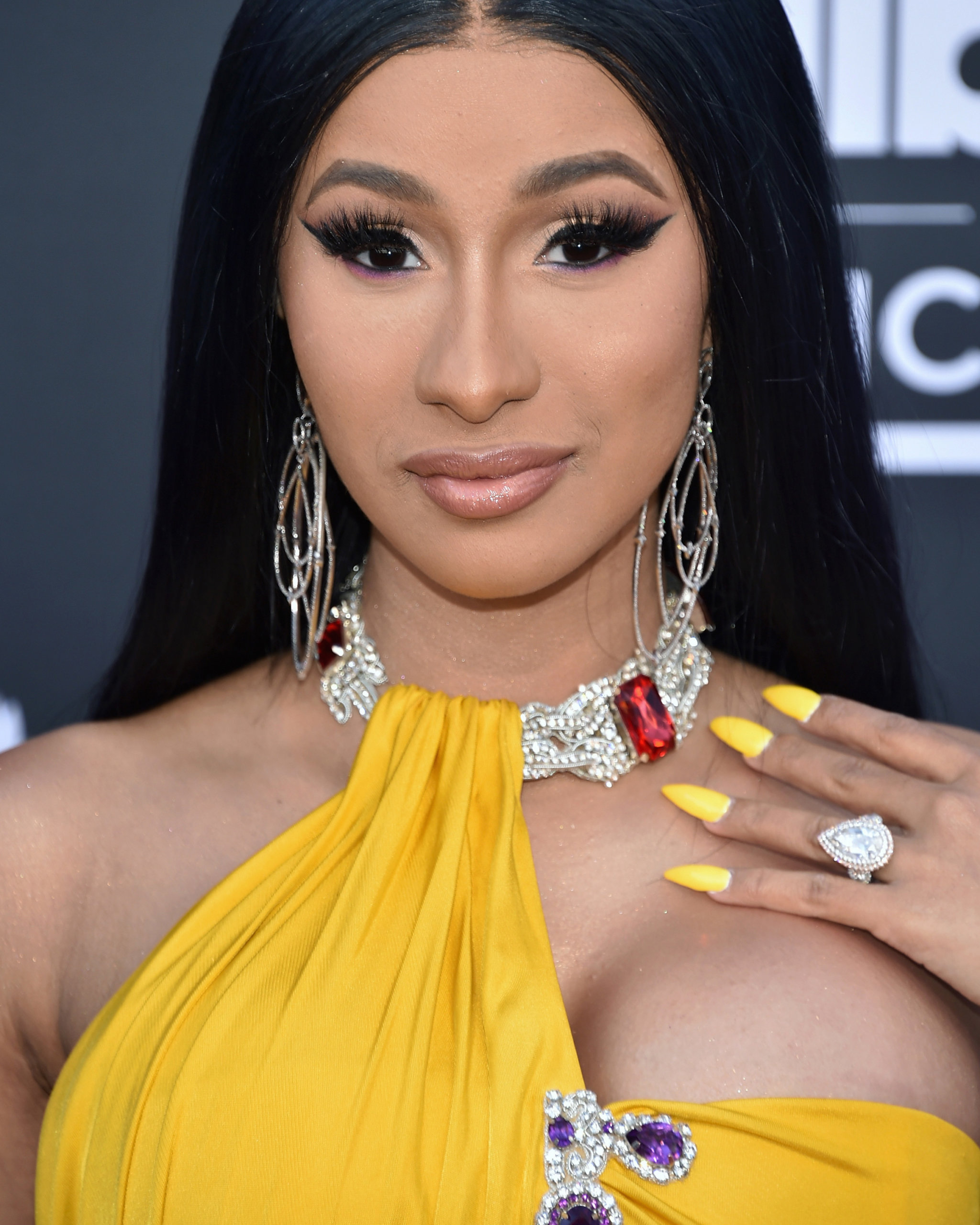 Cardi B red carpet look at the 2019 Billboard Music Award putting on display the infamous Cardi B engagement ring featuring a pear shaped diamond and layered diamond hoop earrings from Loree Rodkin
