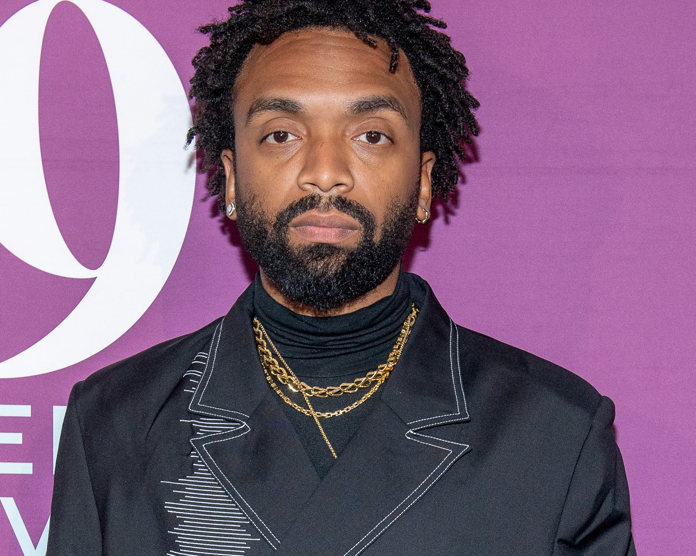 Kerby Jean-Raymond at the 2019 FN Achievement Awards wearing his Pyer Moss suit with John Hardy gold chain necklaces, a diamond Cuban link ring and a white and yellow diamond ring by Shelley & Co