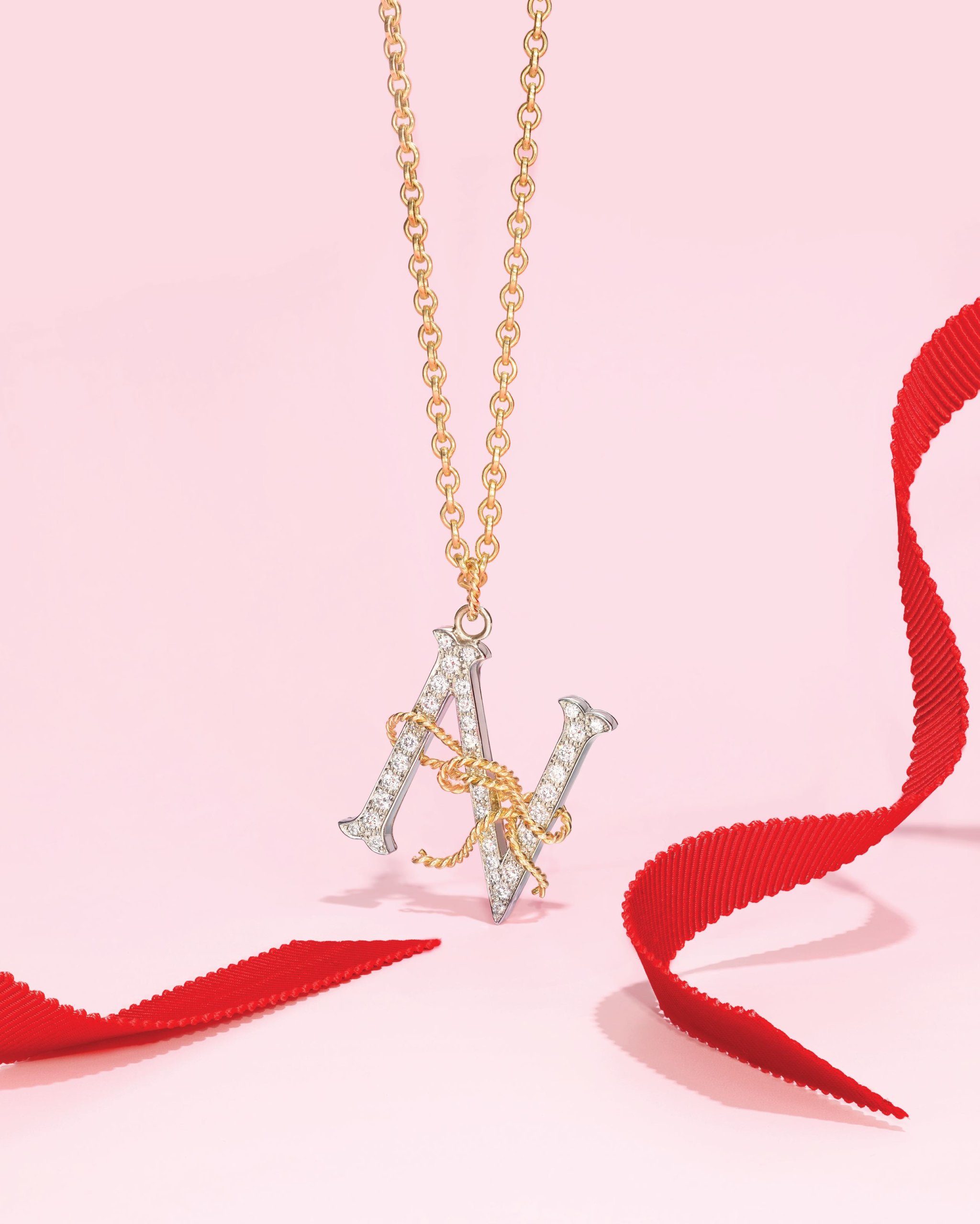 Diamond initial necklace with the letter "N" featuring gold bow detail and set in platinum and yellow gold by Verdura
