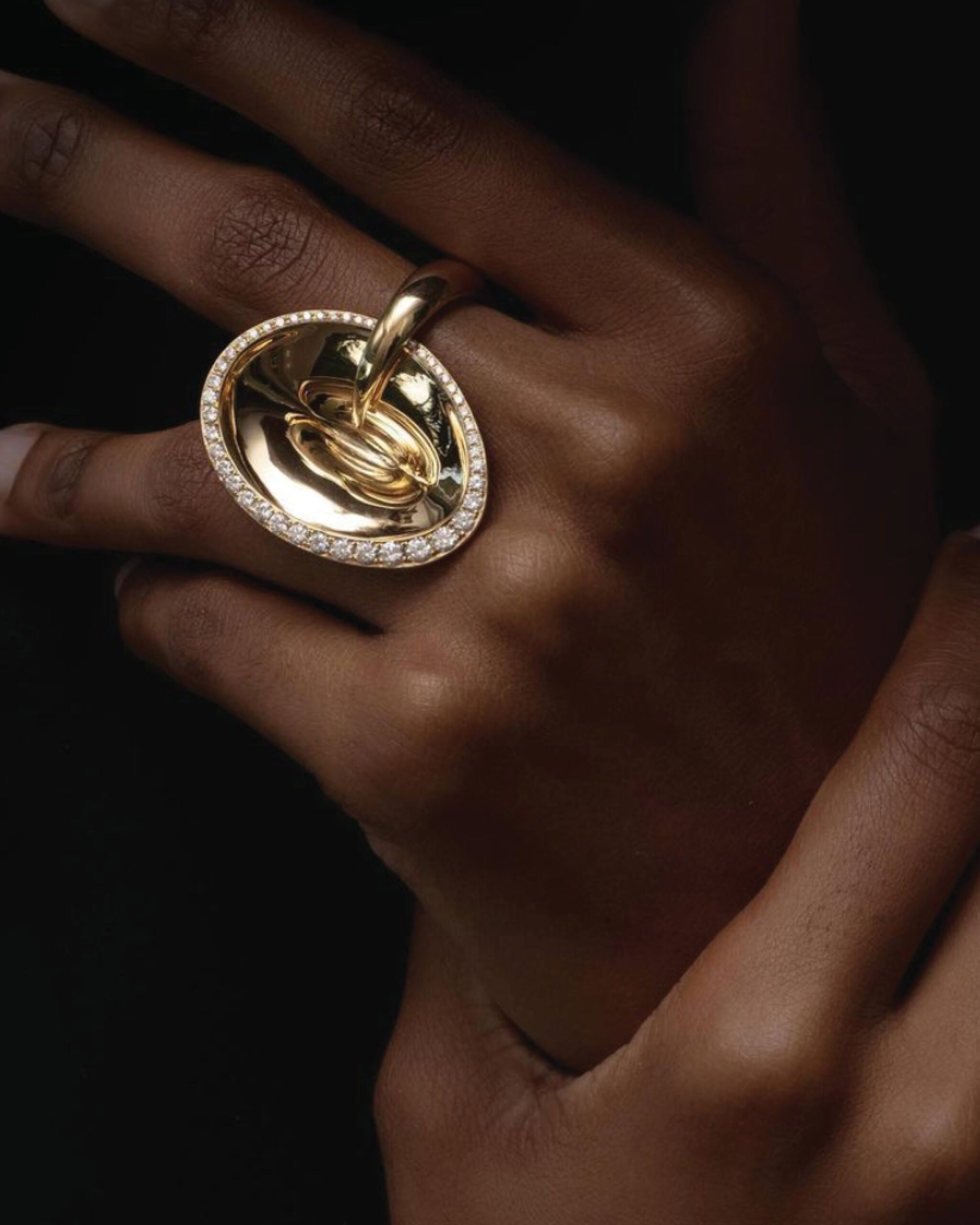 SINE gold cocktail ring from VRAM that features a sculptural gold piece encased in pave diamonds