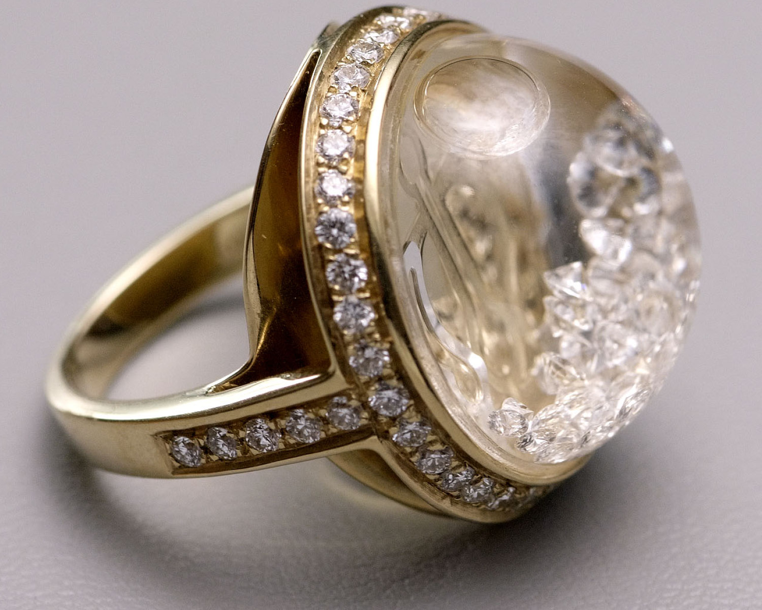 The Lyra Ring in yellow gold with a pavé diamond shank and a dramatic floating diamond dome, a contemporary Royal Asscher design that plays with light and movement.