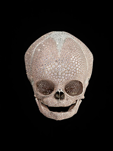 Baby platinum diamond skull paved with pink and white diamonds by Damien Hirst