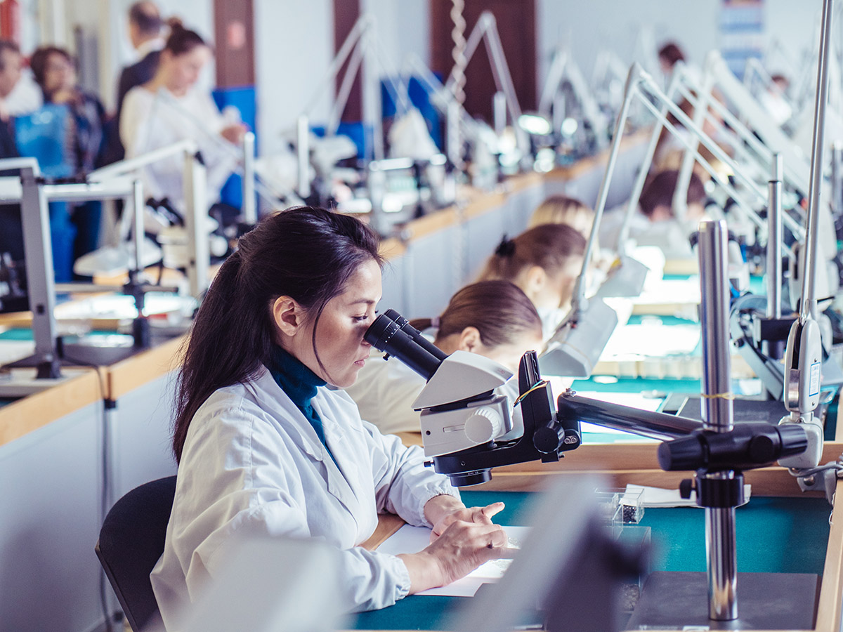 Woman in lab coat examining diamonds, ALROSA