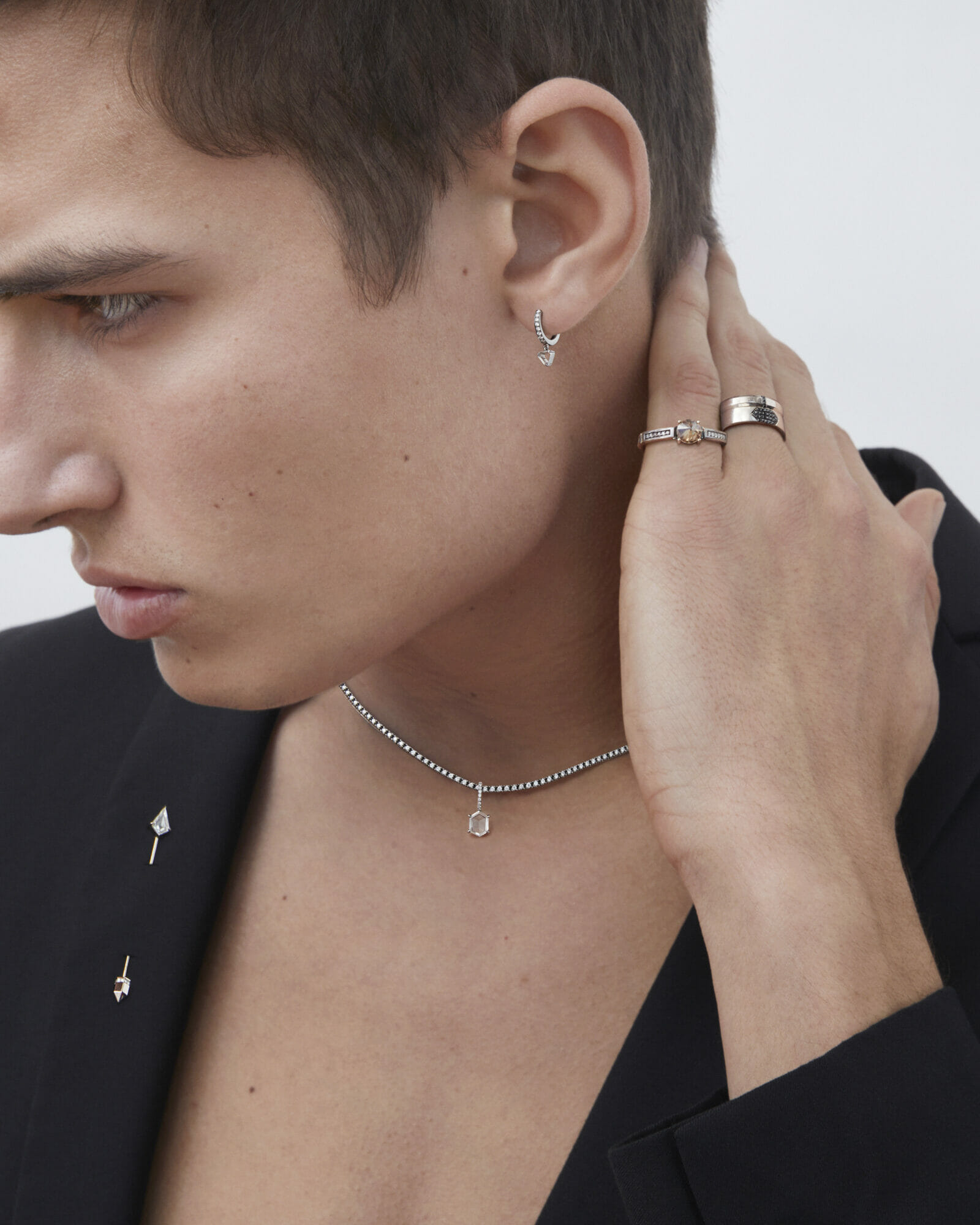 Gender neutral jewelry, man closeup, ring, necklace, earring