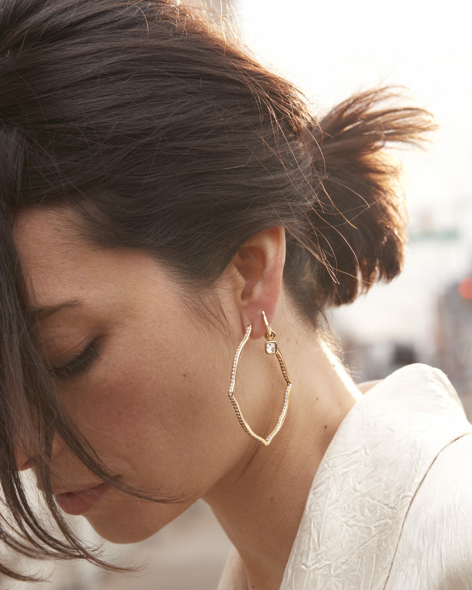New hoops, woman wearing hoop earrings with single diamond