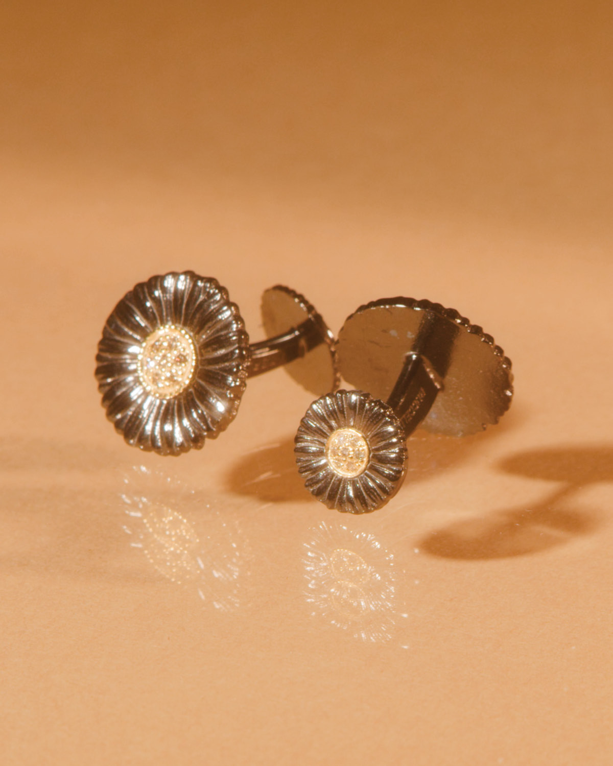 Buccellati blossoms cufflinks in ruthenium, gold and diamonds.