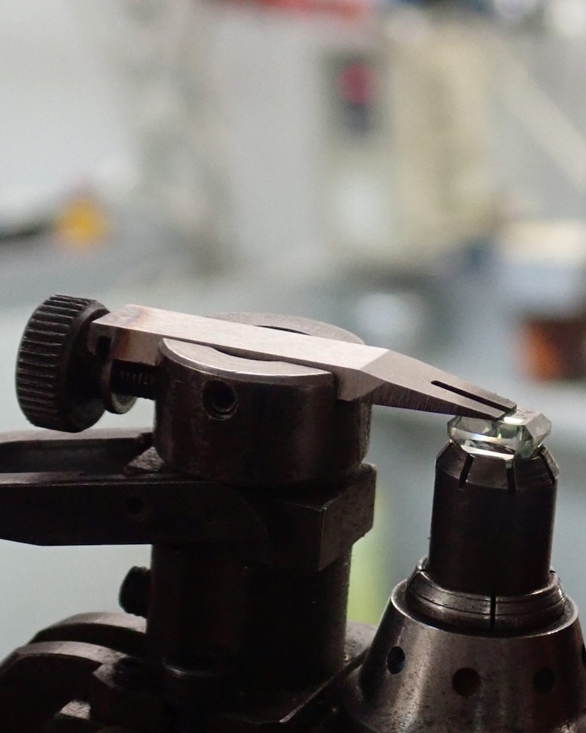 Green diamond in a dop, being examined