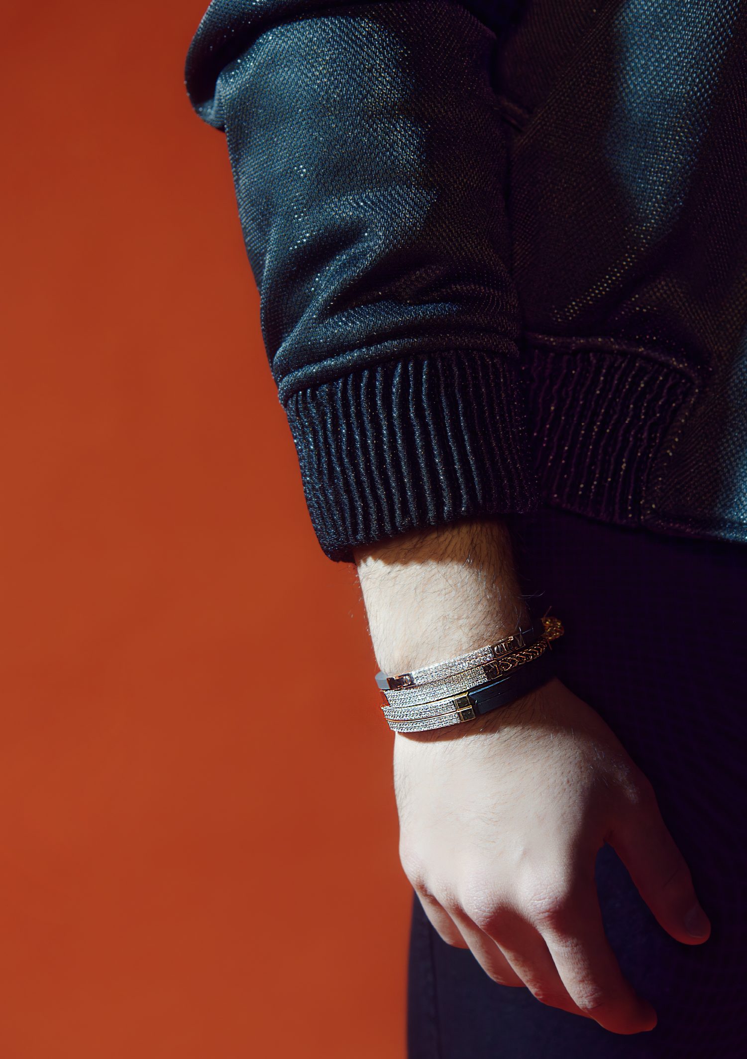 Stacked bracelets with a bold Cuban link chain paired with a chic outfit for a refined look