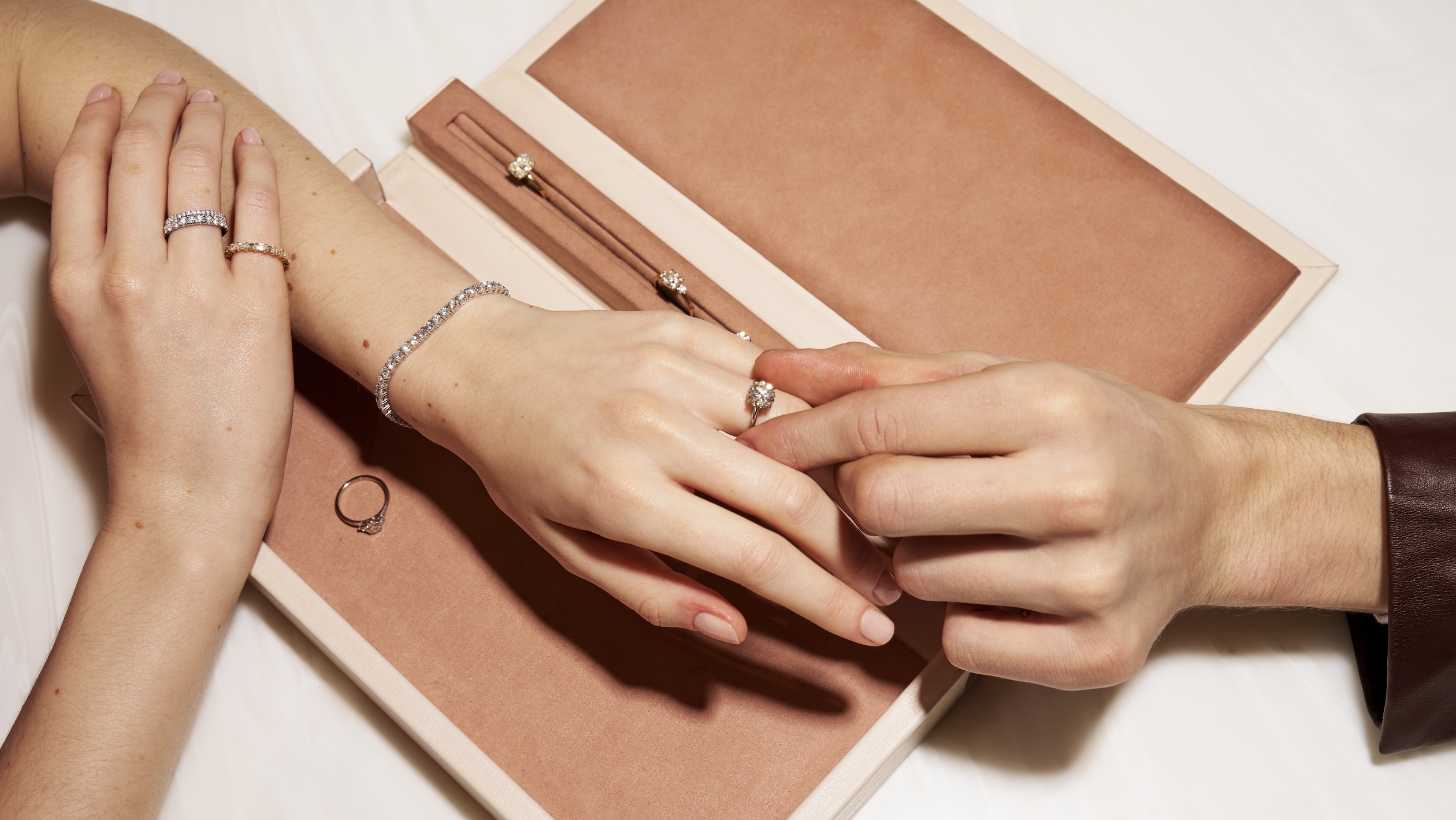 A person putting an engagement ring on a woman's finger natural diamond