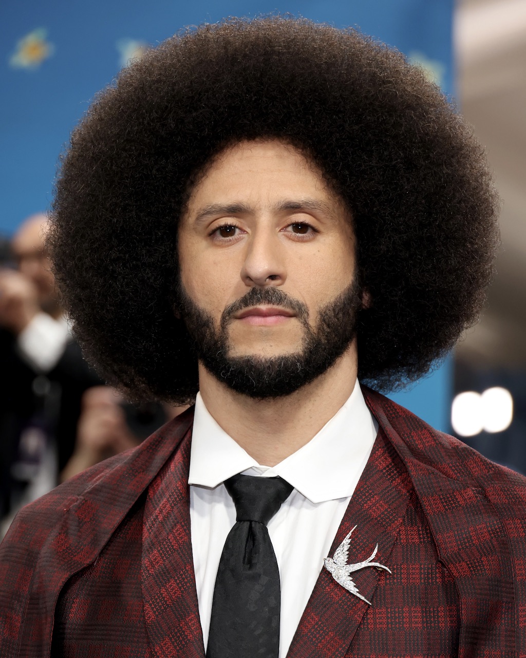 Colin Kaepernick at the 2025 Met Gala wearing a plaid suit and diamond swallow brooch