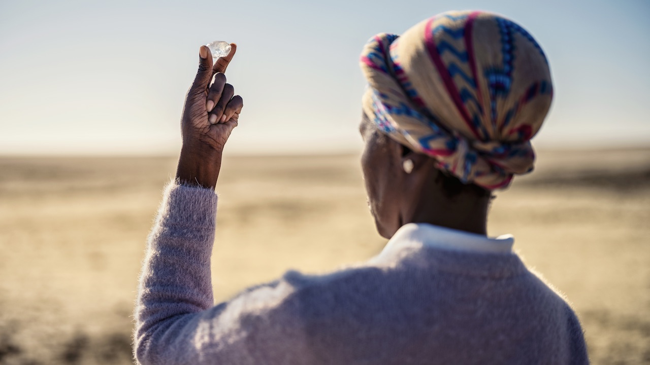 Woman holding a rough diamond in Botswana from the 2025 Jared film by director Luc Jacquet, A Diamond is Born.