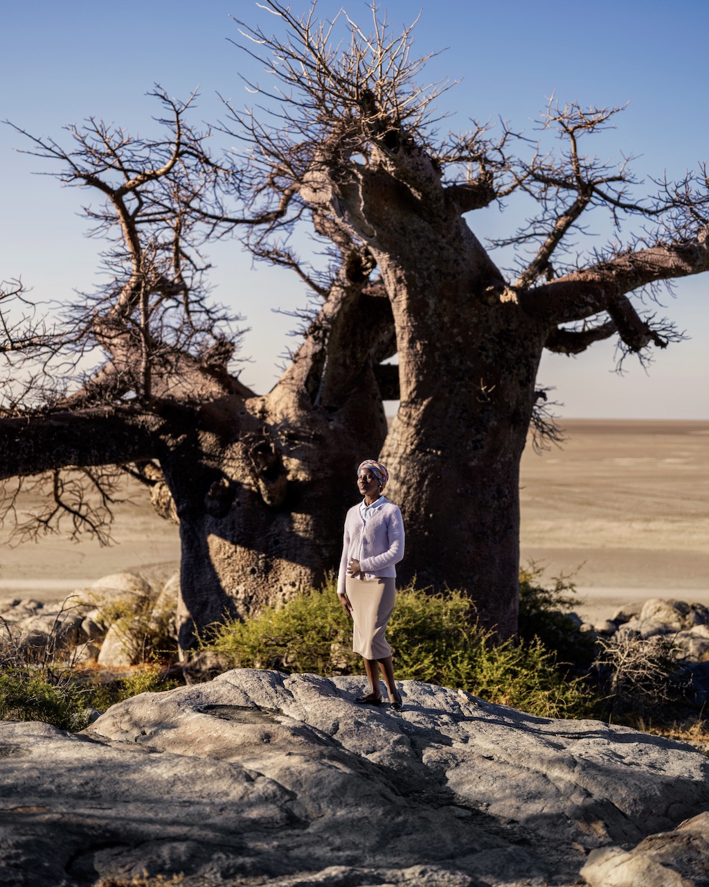 Woman in front of a tree in Botswana from the 2025 Jared film by director Luc Jacquet, A Diamond is Born.