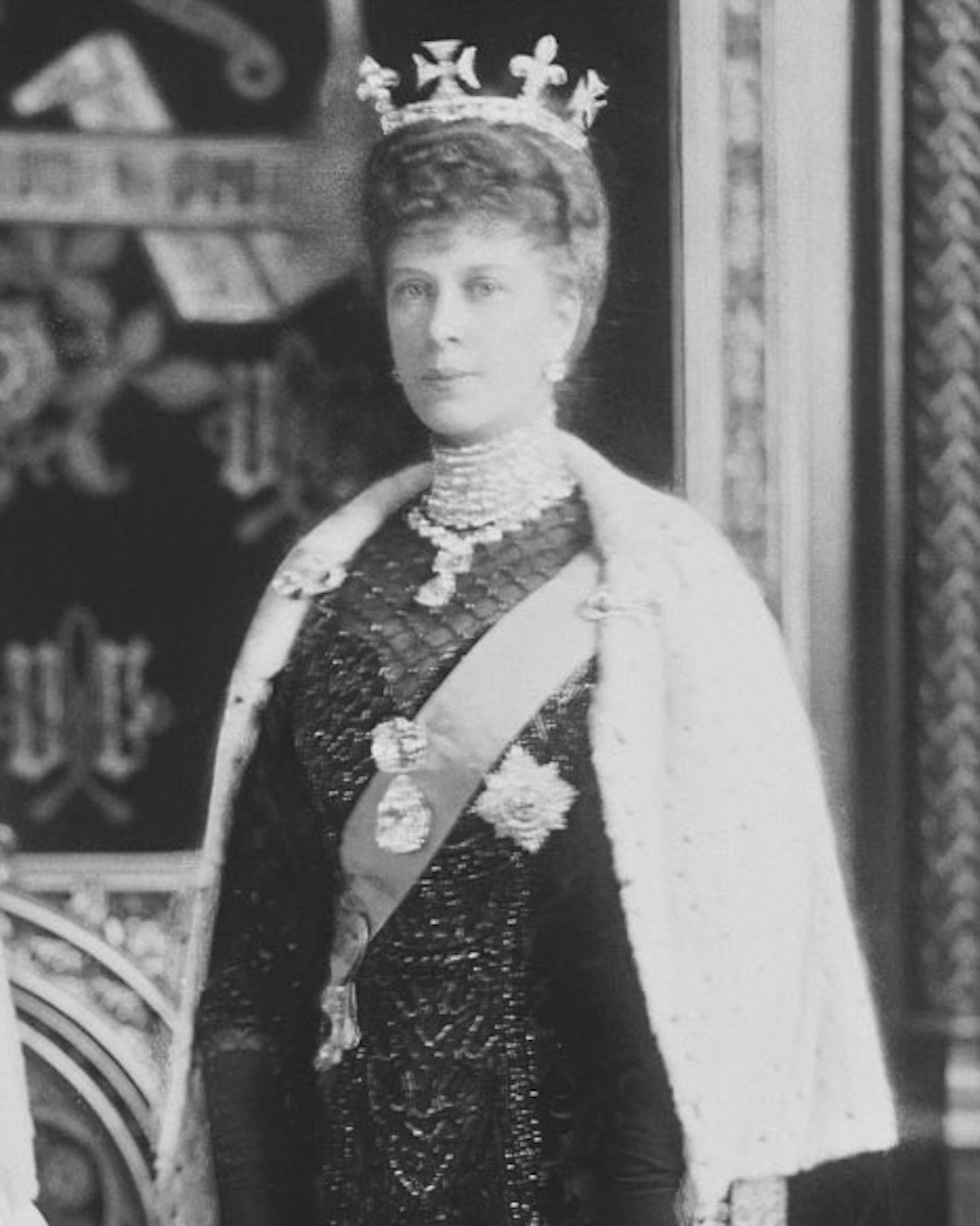 Queen Mary wears the four largest Cullinan diamonds. I and II are on her Garter riband and III and IV are suspended from the Coronation Necklace. The king and queen are dressed for their first State Opening of Parliament.