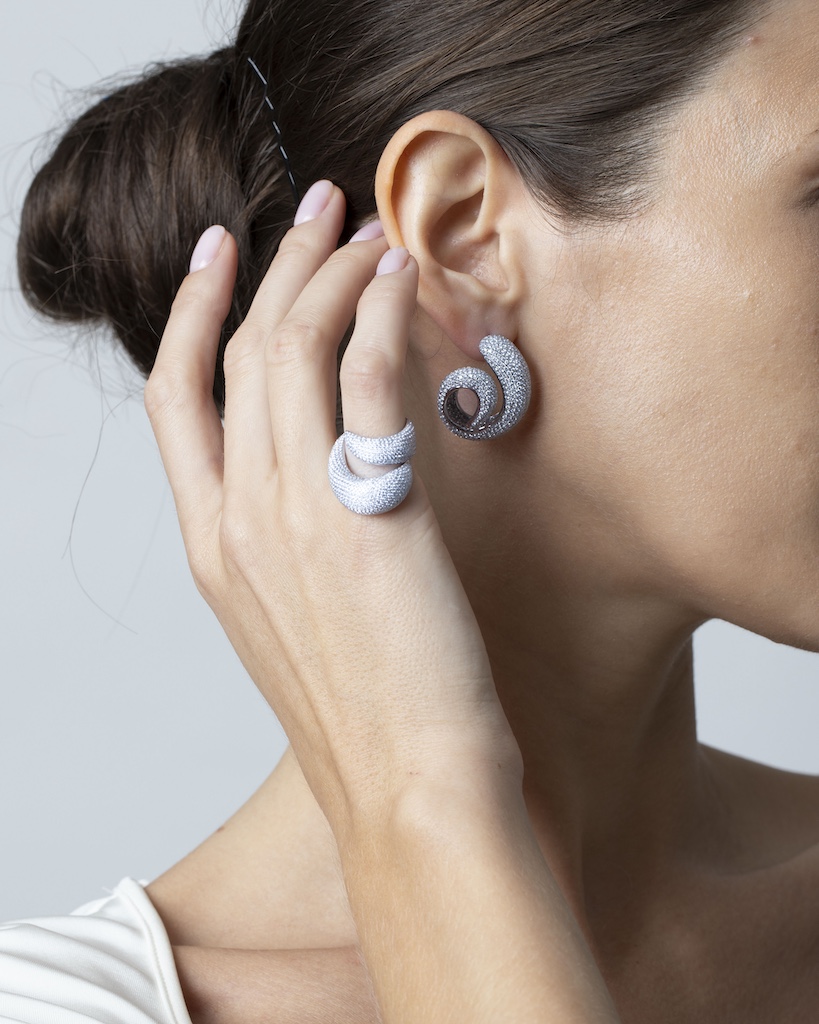 Model wearing pave diamonds earrings and ring. 