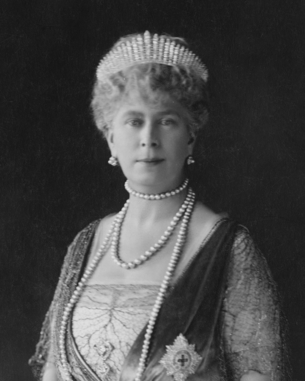 Mary of Teck, Queen Consort of King George V, is pictured wearing the Star of the Order of the Garter and Queen Mary's Fringe tiara, circa 1926