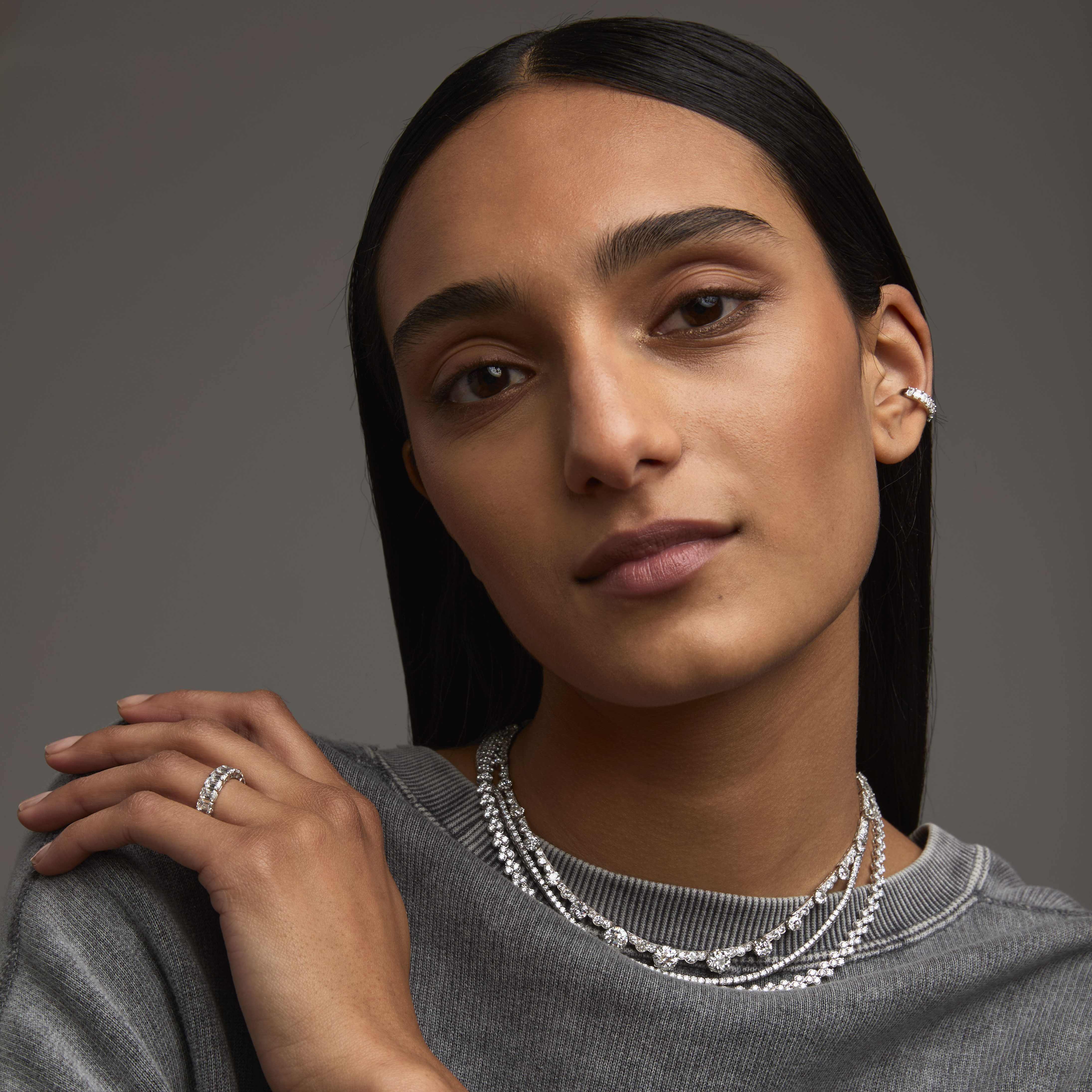 Person wearing natural diamond jewelry and sweater.
