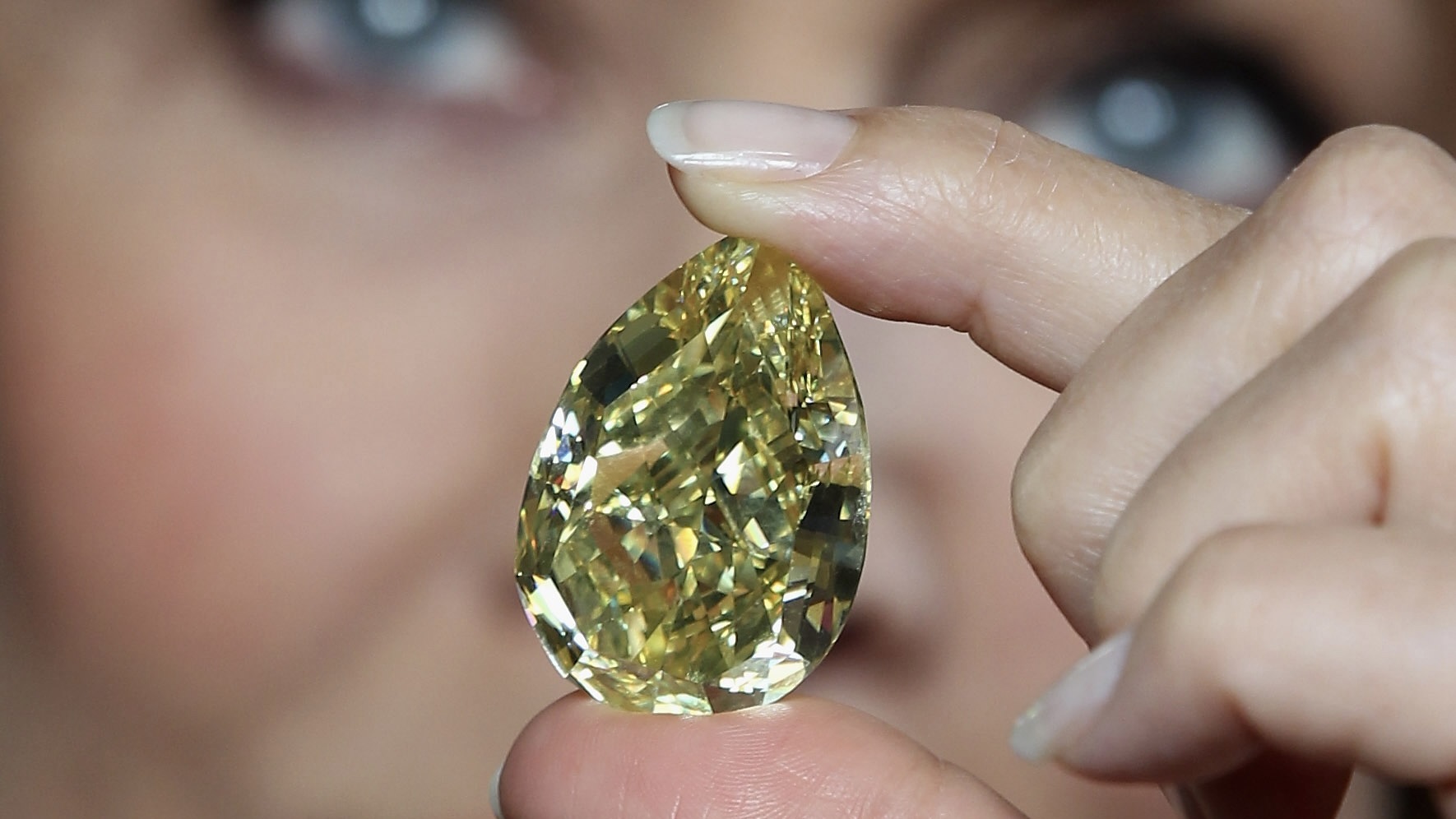 Supermodel Jerry Hall holds the rare 110.03-carat yellow pear-shaped Cora Sun-Drop diamond at the Natural History Museum on February 24, 2011, in London.