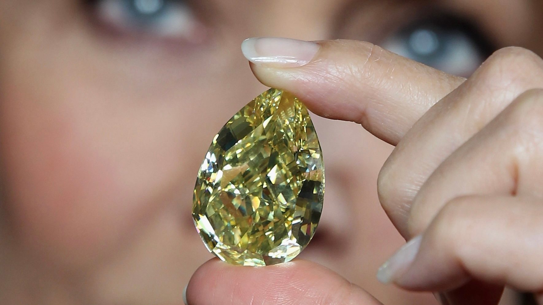 Supermodel Jerry Hall holds the rare 110.03-carat yellow pear-shaped Cora Sun-Drop diamond at the Natural History Museum on February 24, 2011, in London.