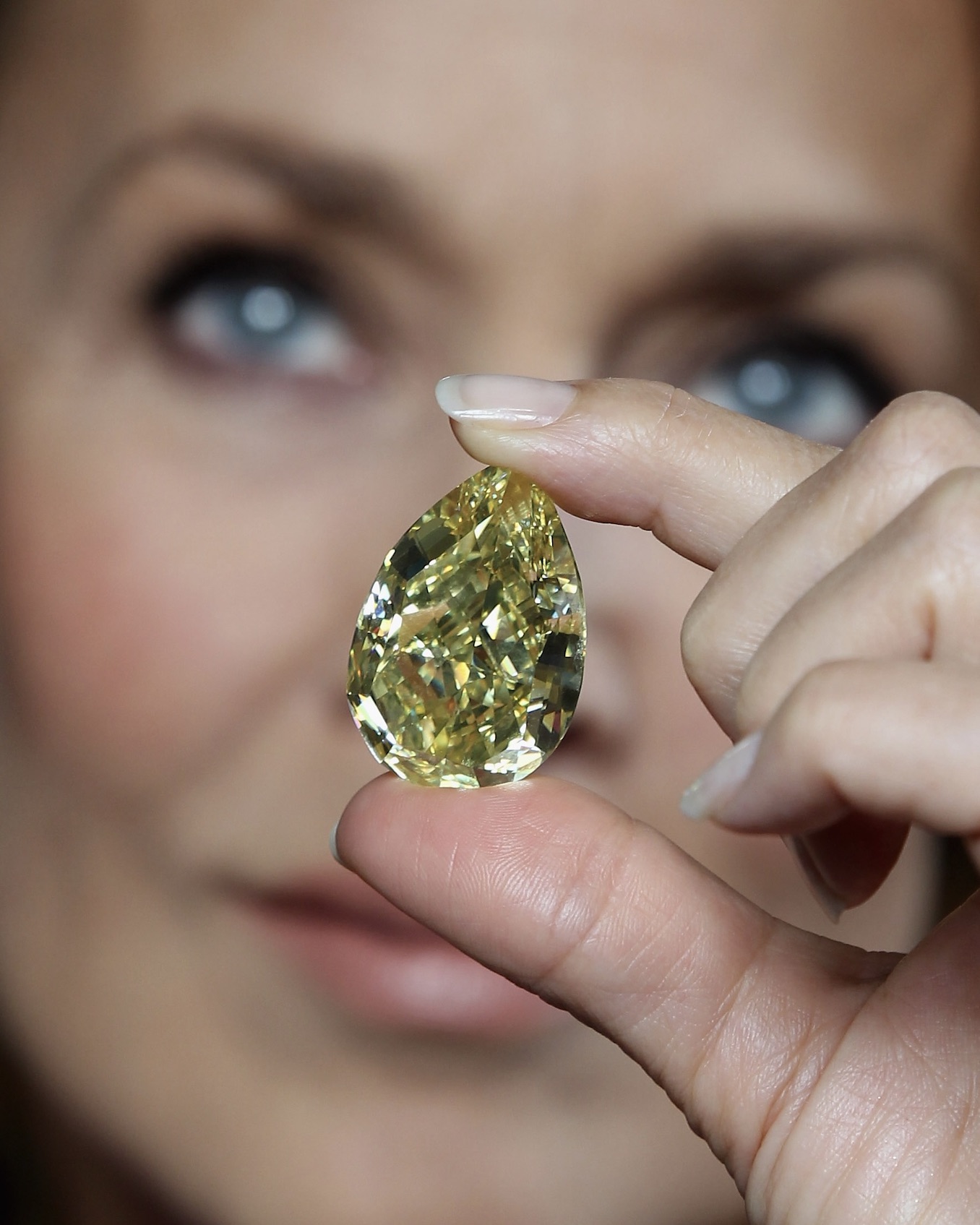 Supermodel Jerry Hall holds the rare 110.03-carat yellow pear-shaped Cora Sun-Drop diamond at the Natural History Museum on February 24, 2011, in London.