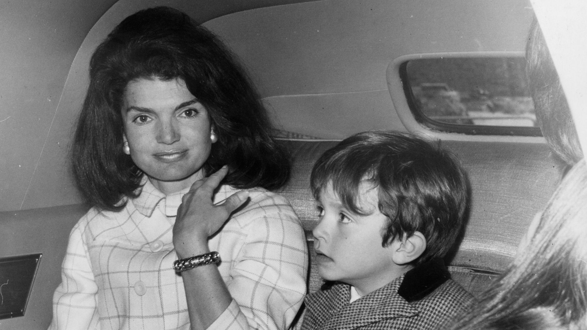 Jacqueline Kennedy in a car with one of her nephews (son of her sister, Princess Radziwill). She is stopping over in London on her way home after a visit to Spain. (Photo by Roger Jackson/Getty Images)