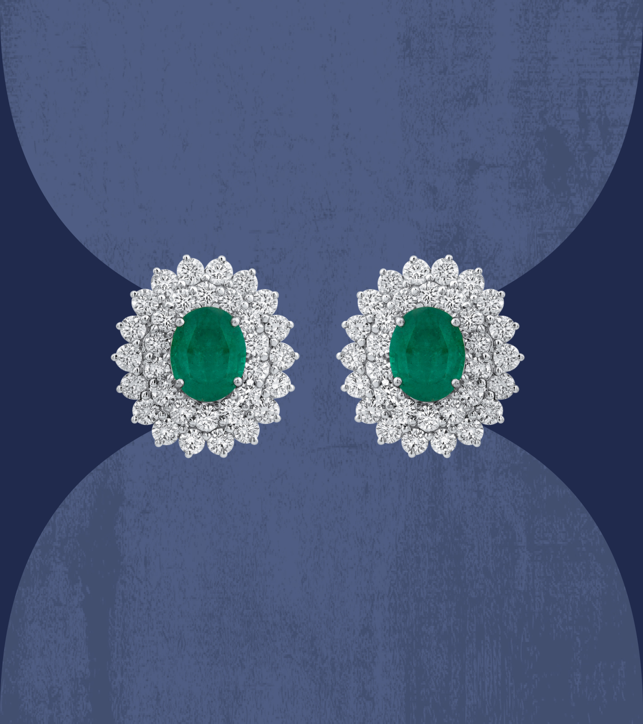 Oval emerald stud earrings with diamond halo