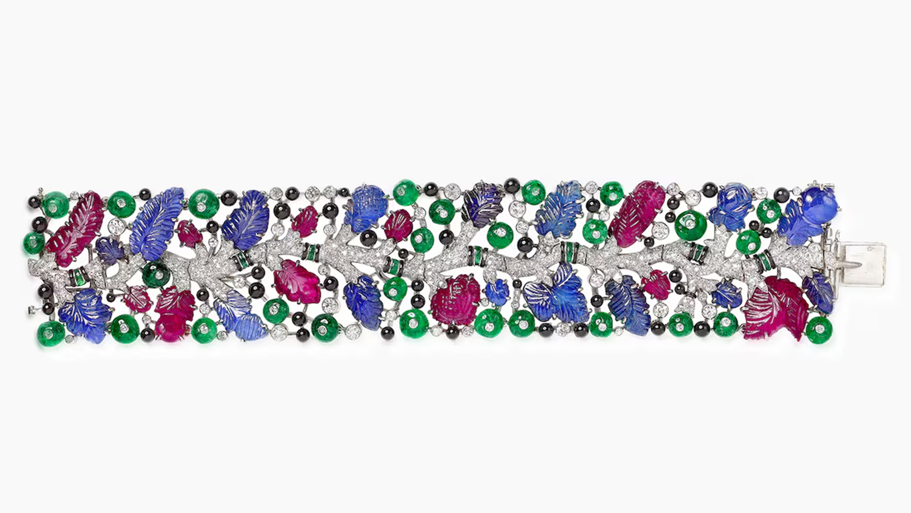 A 1925 Tutti Frutti bracelet showcases Cartier’s signature carved gemstones—rubies, emeralds, and sapphires—set with diamonds in a vibrant, nature-inspired platinum design.
