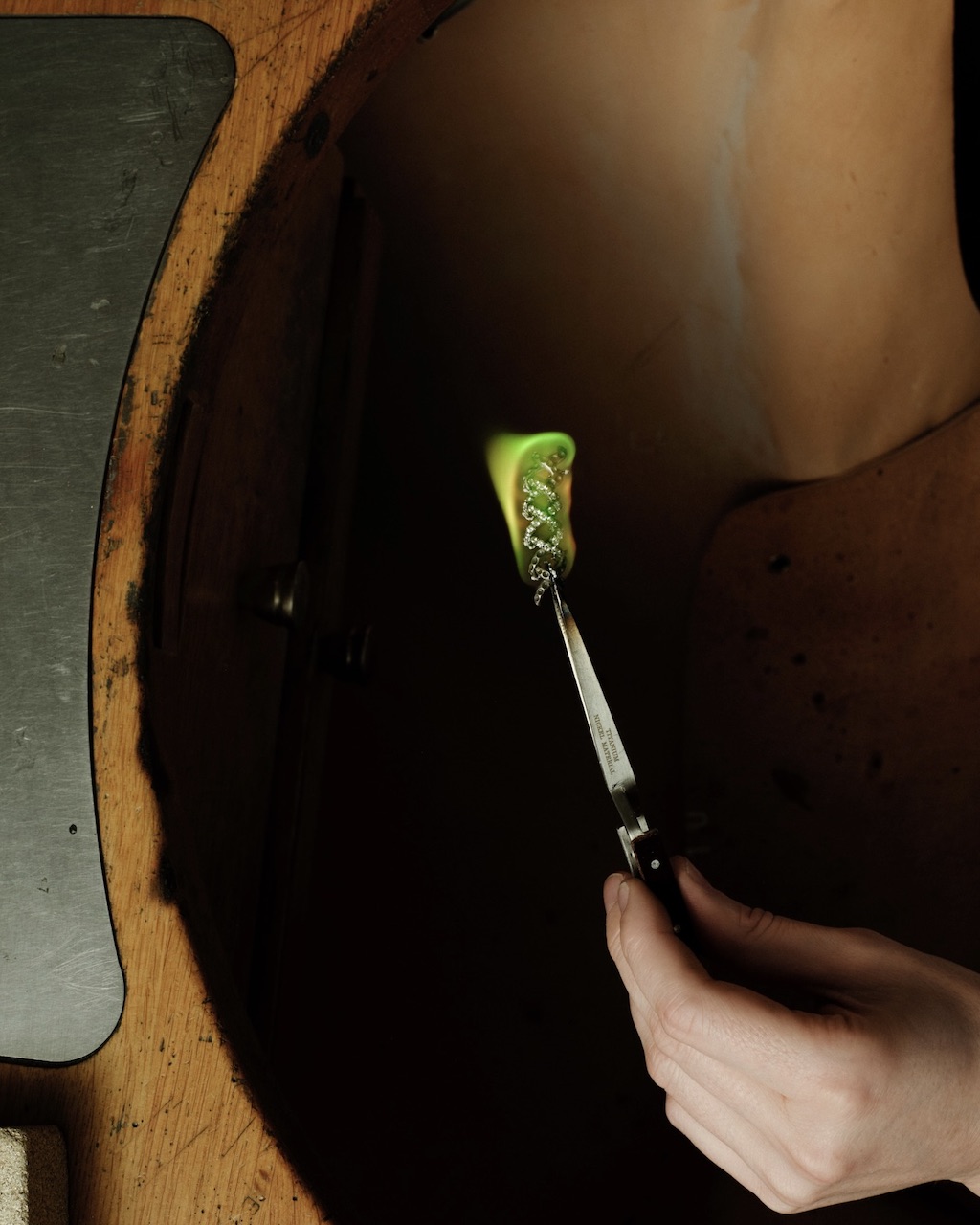 Handcrafting the Diamond Jasmine necklace from Blue Book 2026: Hidden Garden. An artisan holds a casting component.