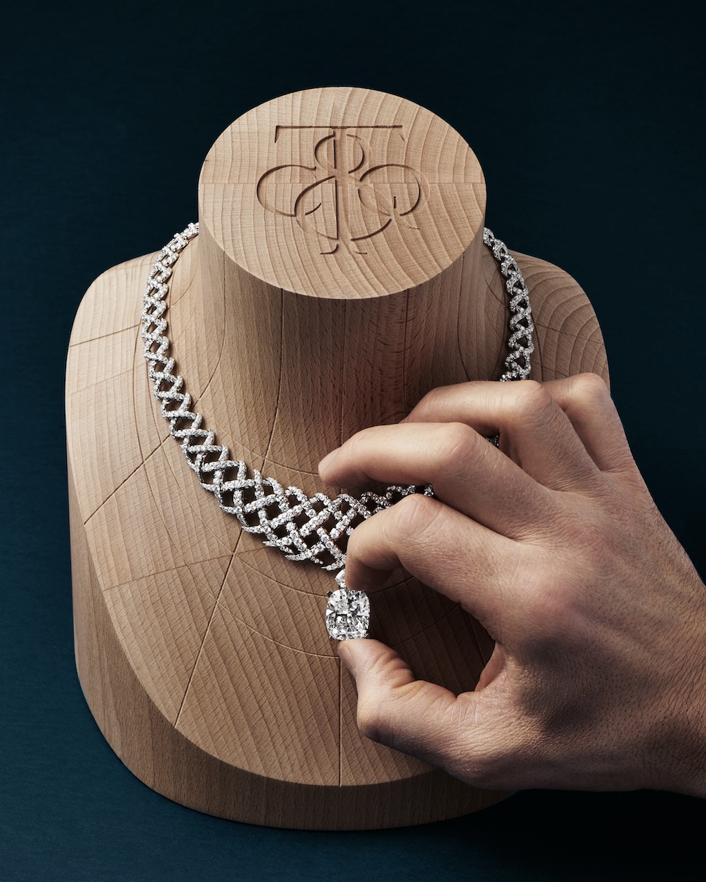 Handcrafting the Diamond Jasmine necklace from Blue Book 2026: Hidden Garden. An artisan examines the fit of a D-color, internally flawless, type IIA cushion-cut diamond of 18.80 carats against its individual basket.