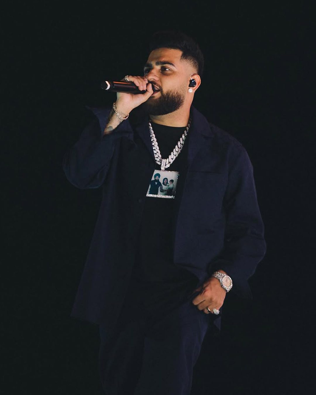 Karan Aujla wearing diamond jewellery on stage